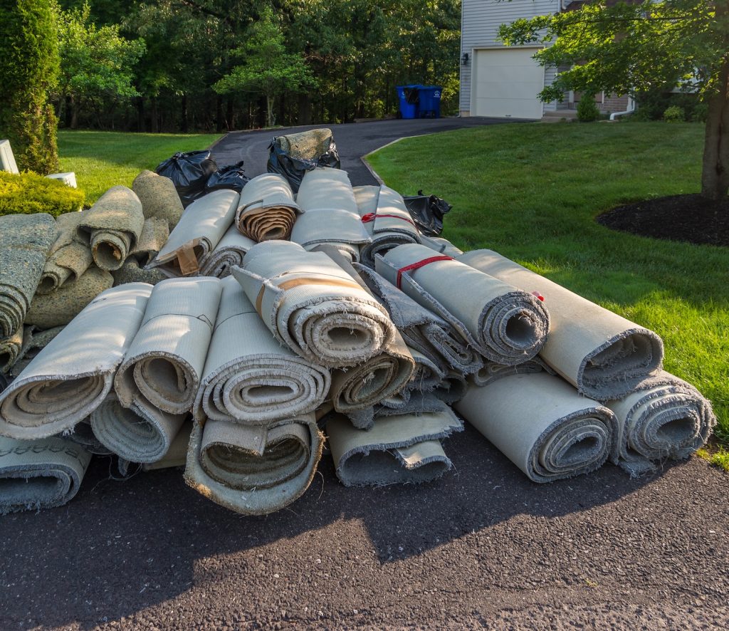 rolls of old carpet on driveway