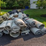 rolls of old carpet on driveway